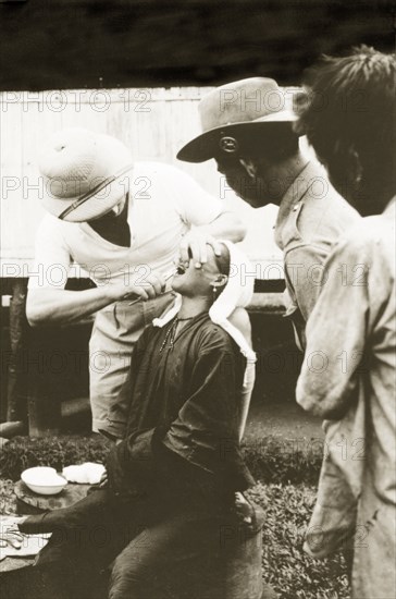 Dental treatment at Keningau Health Centre. A woman recieves dental treatment from a trainee at Keningau Health Centre. Health officers were trained by British medical officers at the centre to introduce new hygiene and sanitation practices to local villages. Keningau, North Borneo (Sabah, Malaysia), circa 1937. Keningau, Sabah (North Borneo), Malaysia, South East Asia, Asia.