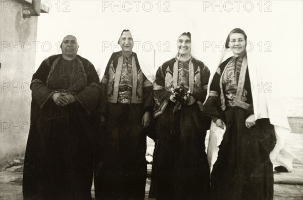 Women in traditional Palestinian attire. Group portrait of four women, dressed in traditional Palestinian 'thobs'. Related photographs show that the woman second from right had recently been married to Edward Keith-Roach, District Governor of Jerusalem, in a traditional Christian ceremony. Jerusalem, British Mandate of Palestine (Israel), circa 1939. Jerusalem, Jerusalem, Israel, Middle East, Asia.
