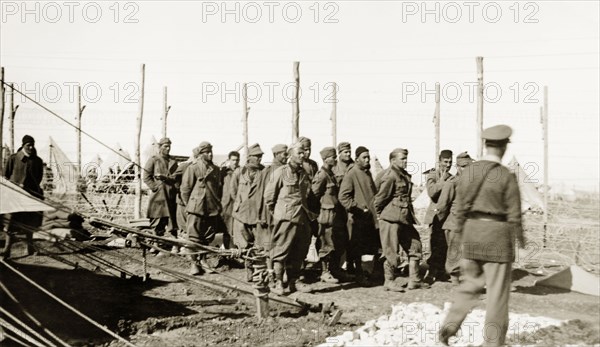 Palestinian soldiers in a fenced compound. A group of Palestinian soldiers, possibly detainees, line up for inspection in the fenced compound at a British Army camp. British Mandate of Palestine (Israel), circa 1940. Israel, Middle East, Asia.