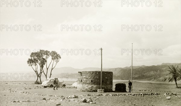 A fortified outpost in Palestine. A British military officer arrives at a fortified outpost in a desert valley, to be met by two Arab soldiers in uniform. British Mandate of Palestine (Israel), circa 1940. Israel, Middle East, Asia.