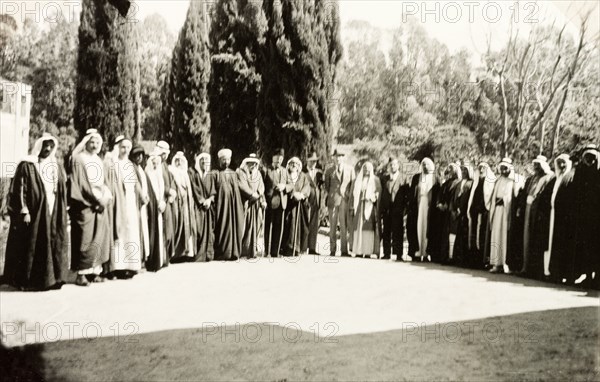 Group portrait of British and Arab officials. A number of British and Arab officials line up for a group portrait in a courtyard outdoors. Probably Acre (Akko), British Mandate of Palestine (Northern Israel), circa 1940. Akko, North (Israel), Israel, Middle East, Asia.