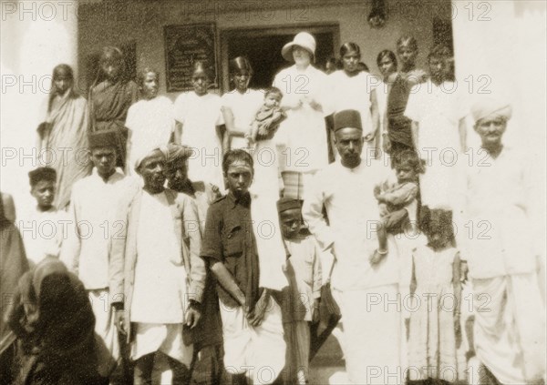 Staff at Mandagadde Hospital. A European doctor and Indian staff from the Mandagadde Methodist Mission Hospital pose for a group portrait with their families on the steps outside. Mandagadde, Mysore State (Karnataka), India, circa 1933., Karnataka, India, Southern Asia, Asia.