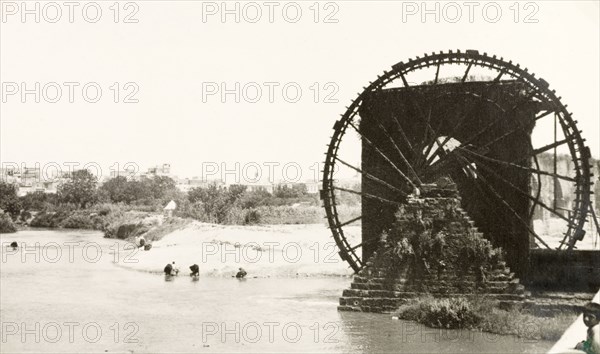 Noria on the Orontes River, Hamah. A huge noria (water wheel) lifts water from the River Orontes into an aqueduct at Hamah. This is one of 16 norias used to irrigate the city, which supposedly date back to 1100BC. Hamah, French Mandate of Syria, July 1941. Hamah, Syria, Syria, Middle East, Asia.