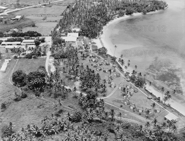 The Koralevu Beach Hotel, Fiji. Aerial view of the Koralevu Beach Hotel, located halfway between the towns of Nadi and Suva. A number of Fijian-style 'bures' (dwellings), used to accommodate tourists, sit in groups along the seafront. Viti Levu, Fiji, 1965., Viti Levu, Fiji, Pacific Ocean, Oceania.