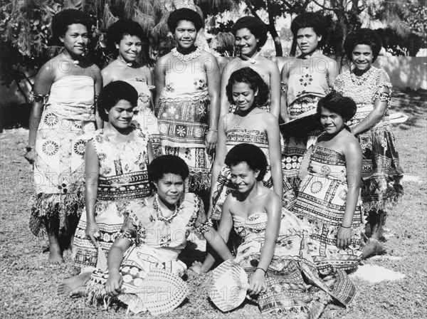 Fijian women wearing 'masi' cloth. A group of Fijian women pose for a portrait, wearing printed 'masi' (bark cloth) costumes. Nasilai, Viti Levu, Fiji, 1965. Nasilai, Viti Levu, Fiji, Pacific Ocean, Oceania.