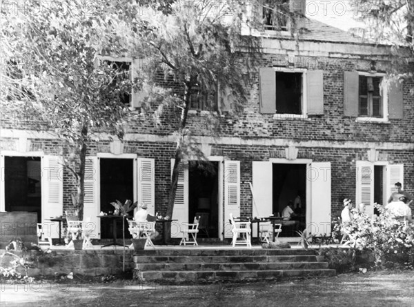 The Admiral's Inn, Antigua. The louvered doors of the historic Admiral's Inn open out onto a stone terrace covered with chairs and tables at Nelson's Dockyard. English Harbour, Antigua, 1965. English Harbour, St Paul (Antigua and Barbuda), Antigua and Barbuda, Caribbean, North America .