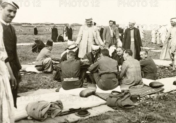 Recruitment meeting at Al Faluja. British colonial and military officers sit on padded mats and cushions as they talk to Arab villagers at a military recruitment meeting. Al Faluja, British Mandate of Palestine (South Israel), 1944., South (Israel), Israel, Middle East, Asia.