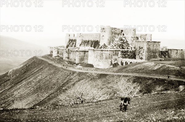 The Krak de Chevaliers. View of the Krak de Chevaliers, located atop a hill in the Homs Gap. Once the headquarters of the Knights Hospitaller during the Crusades (1095-1291), it controlled the road to the Mediterranean and is one of many fortresses that formed a defensive network along the border of the old Crusader states. Homs (Hims), French Mandate of Syria, 1944. Hims, Syria, Syria, Middle East, Asia.