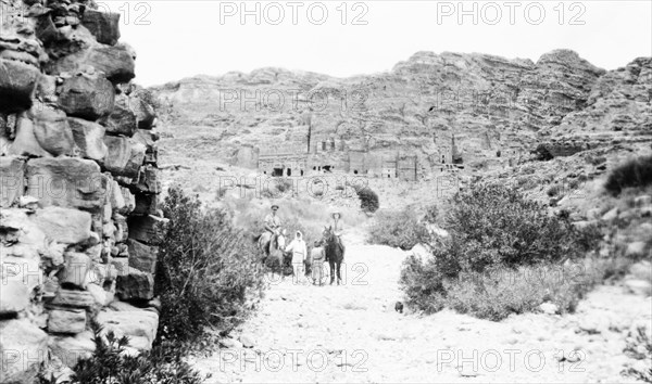 In the valley below Petra. Arab guides lead a European couple on horseback as they visit the cliff structures at Petra, an ancient Nabatean city on the eastern flank of the Arabah. Petra, Transjordan (Jordan), May 1945., Jordan, Jordan, Middle East, Asia.