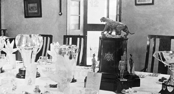 A table set for a formal dinner. Various trophies form the centrepiece of a table that has been set for a formal dinner for the Inspector-General of Police, Harold Poe, at Moradabad's Police Training School. Moradabad, United Provinces (Uttar Pradesh), India, circa 1933. Moradabad, Uttar Pradesh, India, Southern Asia, Asia.