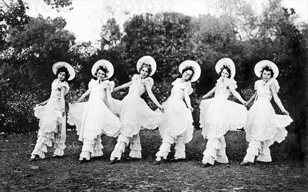 Chorus line act at a garden party. Members of the cast of 'Flying Fragments' in hoop skirts, performed by the Moradabad Amateur Dramatic Society at the Railway Institute. Moradabad, United Provinces (Uttar Pradesh), India, 12 February 1934. Moradabad, Uttar Pradesh, India, Southern Asia, Asia.