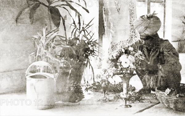 A servant tending to houseplants. A gardener arranges a vase of flowers at the Police Training School, Moradabad, United Provinces (Uttar Pradesh), India, 1934. Meerut, Uttar Pradesh, India, Southern Asia, Asia.