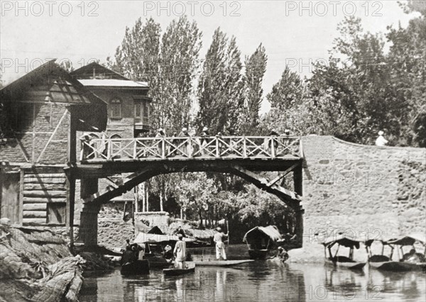 Canal footbridge in Srinagar. Water taxis pass beneath a wooden footbridge on a Srinagar canal. Srinagar, Jammu and Kashmir, India, 1934. Srinagar, Jammu and Kashmir, India, Southern Asia, Asia.