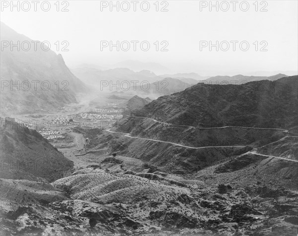Military camp on the Khyber Pass. Two roads wind towards an Indian Army camp, located in a mountain valley on the Khyber Pass. The camp is protected by earthworks and contains numerous bell tents. North West Frontier Province, India (Federally Administered Tribal Areas, Pakistan), circa 1919., Federally Administered Tribal Areas, Pakistan, Southern Asia, Asia.