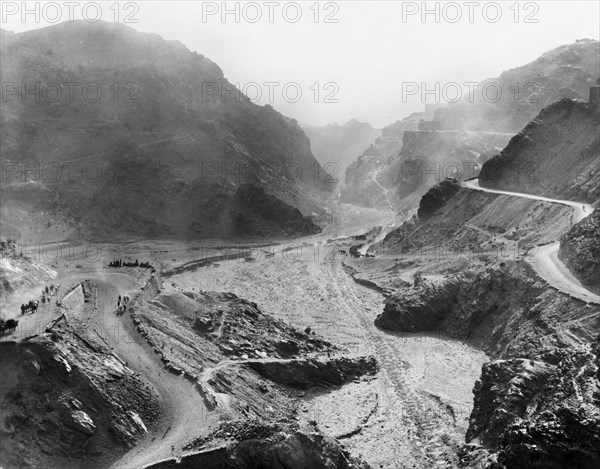 Jangi Gorge in the Khyber Pass. Cattle and horses are herded along the road to Landi Khana, which winds its way through the Jangi Gorge in the Khyber Pass. An original caption comments: "Two miles further along (this) road is the extreme (north west) corner of British India". North West Frontier Province, India (Federally Administered Tribal Areas, Pakistan), 1919., Federally Administered Tribal Areas, Pakistan, Southern Asia, Asia.