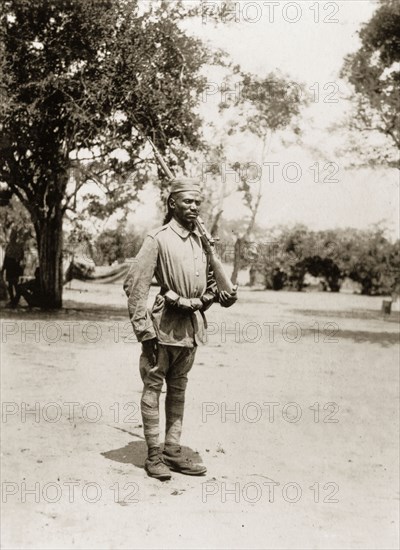 Portrait of an African schutztruppe. Portrait of an African schutztruppe, his rifle slung over his shoulder. German East Africa (Eastern Africa), 1910., Eastern Africa, Africa.