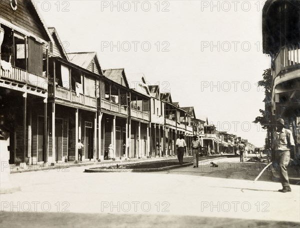 City street in Colon, Panama. Wooden, balconied buildings line the main street running through the port city of Colon. Colon, Panama, circa 1930. Colon, Colon, Panama, Central America, North America .