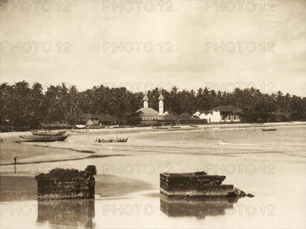 Madayi Mosque in Kannur. View across a sandy bay looking towards Madayi Mosque. The white marble mosque was originally built in 1124 AD by Malik Bin Deenar, a Muslim preacher. Cannanore (Kannur), Kerala, India, circa 1936. Kannur, Kerala, India, Southern Asia, Asia.