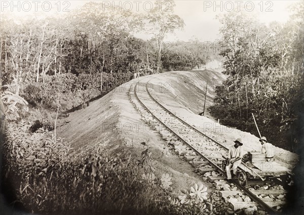 A newly completed section of the Siparia line. Two Trinidad Government Railway workers sit on a hand-operated cart on a newly completed section of the Siparia extension line. Near Siparia, Trinidad, 3 April 1914. Siparia, Trinidad and Tobago, Trinidad and Tobago, Caribbean, North America .