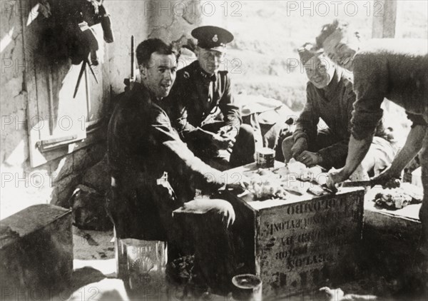 Army and police share a meal, Palestine. British military and police officers sit on oil cans around an up-ended tea crate as they share a meal. During the period of the Great Uprising (1936-39), an additional 20,000 British troops were deployed to Palestine in an attempt to clamp down on Arab dissidence. Tilfit, British Mandate of Palestine (West Bank, Middle East), 1938., West Bank, West Bank (Palestine), Middle East, Asia.