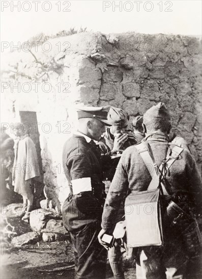 Police and army cooperation' in Samaria. British soldiers and police gather outside a village dwelling during operations in the region of Samaria. During the period of the Great Uprising (1936-39), an additional 20,000 British troops were deployed to Palestine in an attempt to clamp down on Arab dissidence. Tilfit, British Mandate of Palestine (West Bank, Middle East), 1938., West Bank, West Bank (Palestine), Middle East, Asia.