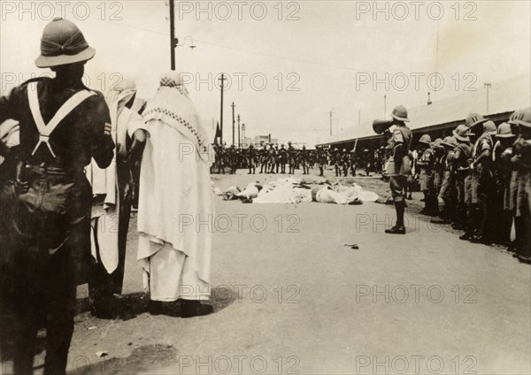 Casualties in Palestine, circa 1938. A British Army officer uses a loudhailer to address his troops over a heap of corpses lying on a city street. These were probably civilian casualties, victims of the violent clashes between Palestinian Arabs and Jews during the Great Uprising (1936-39), when an additional 20,000 British troops were deployed to Palestine. British Mandate of Palestine (Middle East), circa 1938., Middle East, Asia.