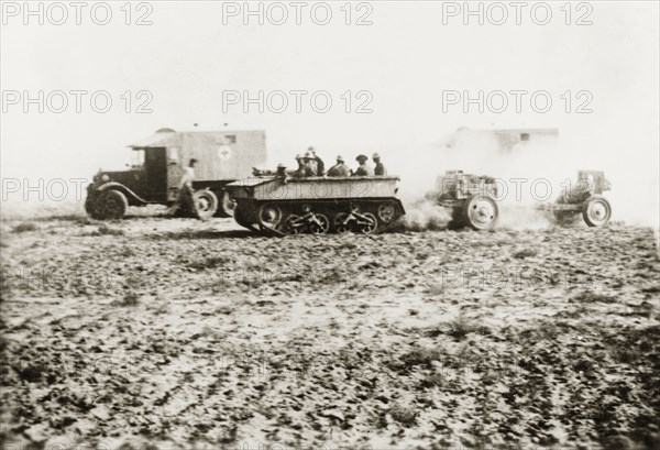 British medical trucks and tanks in Palestine. Ambulance trucks of the Royal Army Medical Corps and an armoured tank cross an open patch of ground in the Palestinian countryside. During the period of the Great Uprising (1936-39), an additional 20,000 British troops were deployed to Palestine in an attempt to clamp down on Arab dissidence. British Mandate of Palestine (Middle East), circa 1938., Middle East, Asia.
