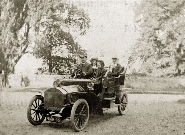 Edwardian family in a motorcar. A British family, dressed in their best attire, drive a motorcar proudly into town. Probably England, circa 1910. England (United Kingdom), Western Europe, Europe .