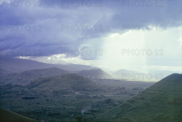 Storm over the Virunga Mountains. A shaft of light streams down between storm clouds over the Virunga Mountains. Kigezi, South West Uganda, September 1963., West (Uganda), Uganda, Eastern Africa, Africa.