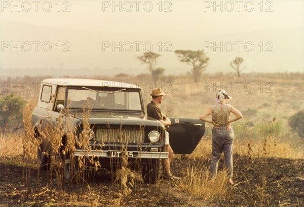 Elisabeth Lang Brown and Svend Sorendsen. Elisabeth, the wife of District Forestry Officer James Lang Brown, surveys the Ankole bush with Svend Sorendsen, a Danish employee of the Tsetse Control Department. West Uganda, March 1964., West (Uganda), Uganda, Eastern Africa, Africa.