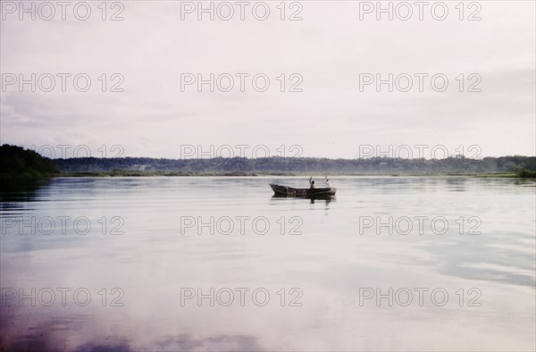 Fishing off Buvuma Island. Two early-morning fishermen man a small boat off Buvuma Island, on the calm waters of Lake Victoria. Uganda, 1962., Central (Uganda), Uganda, Eastern Africa, Africa.