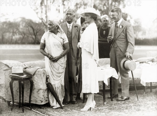Standing in comfort on the lawn. Sir Maurice and Lady Hallett with guests at their garden party. Lucknow, Uttar Pradesh, India. 24 February 1940 Lucknow, Uttar Pradesh, India, Southern Asia, Asia.