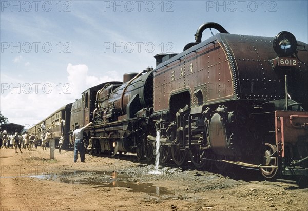 East African Railways train on the Uganda Railway. Passengers board an East African Railways train at Nairobi station. Kenya, 1955. Uganda, Eastern Africa, Africa.