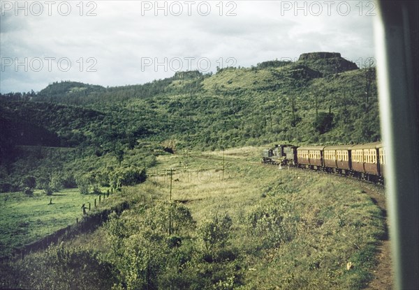 Through the Aberdare Mountains'. A train winds its way through the Aberdare Mountains on the Uganda Railway. Kenya, 1955. Kenya, Eastern Africa, Africa.