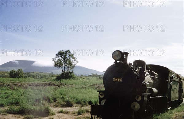 Construction train on the Western Ugandan Extension. A construction train travels along the Western Ugandan Extension, a section of railway track built to transport partially refined copper ore down country. Near Kasese, West Uganda, 1956. Kasese, West (Uganda), Uganda, Eastern Africa, Africa.
