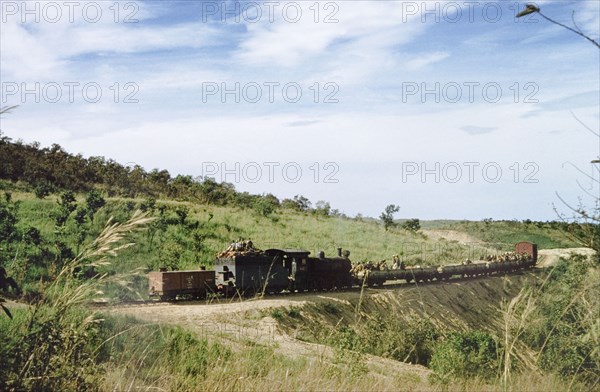 Construction train on the Western Ugandan Extension. Labourers going to work travelling on a construction train on the Western Ugandan Extension, a section of railway track built to transport partially refined copper ore down country. Near Kasese, West Uganda, 1956., West (Uganda), Uganda, Eastern Africa, Africa.