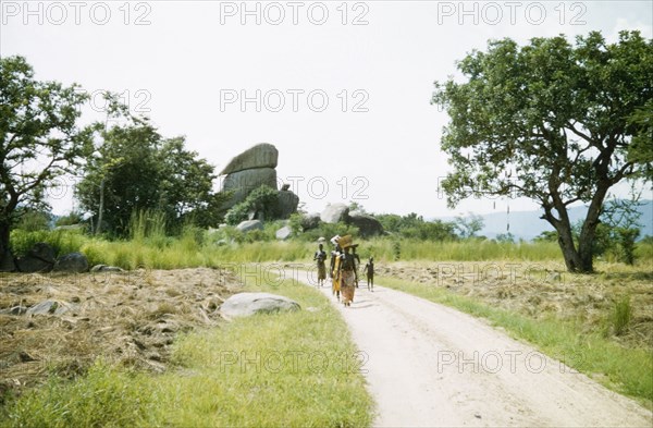 A rural road in West Nile. A small group of women and children walk along the main road to Arua. Uganda's West Nile district, 1956., East Equatoria, Sudan, Eastern Africa, Africa.