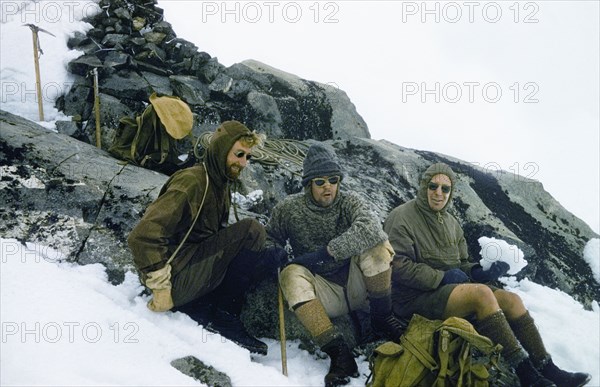 Mountaineers at the summit of Mount Speke. Three mountaineers rest at the summit of Mount Speke in the Rwenzori (Ruwenzori) Mountains. Left to right: James Lang Brown (District Forest Officer. Toro), David Pasteur (Assistant District Commissioner, Toro) and George Webb (Assistant District Officer, Kakamega). Kenya, 26 December 1956., West (Uganda), Uganda, Eastern Africa, Africa.