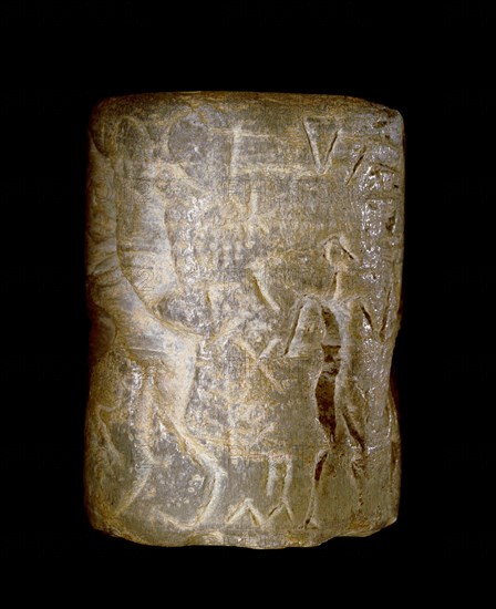 Early dynastic Sumerian alabaster cylinder seal, inscribed with a scene of a seated figure being handed a beaker by an attendant, and a nude hero, conventionally regarded as Gilgamesh, in conflict with animals including two bulls and a lion