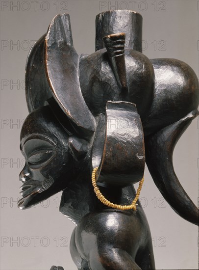 Chief holding a sanza, a musical instrument of the ideophone family, with metal keys and gourd resonator