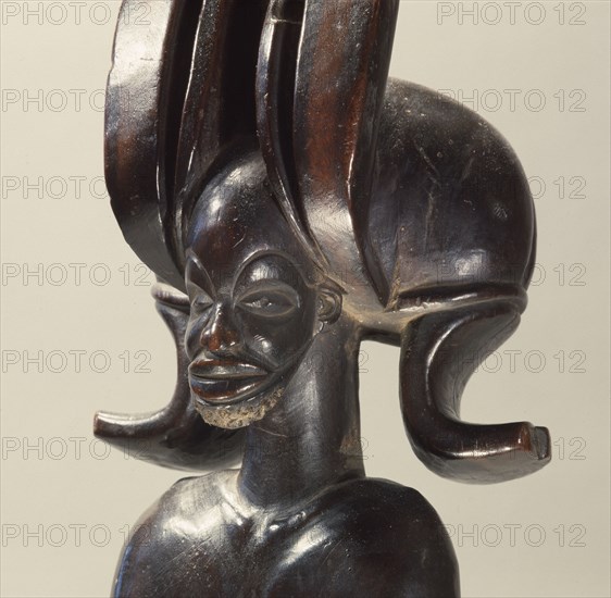 Wood figure of wearing headdress that is characteristic of Chokwe chiefs and also found on important masks