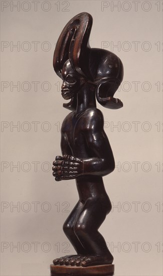 Wood figure wearing headdress that is characteristic of Chokwe chiefs and also found on important masks