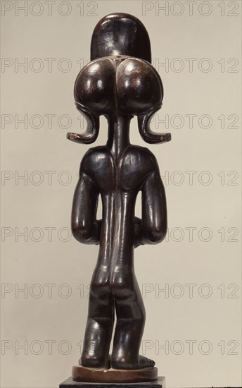 Wood figure of wearing headdress that is characteristic of Chokwe chiefs and also found on important masks