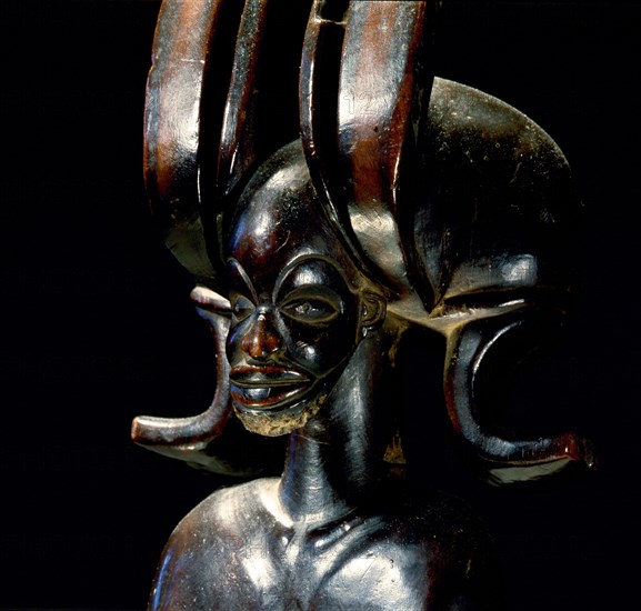 Wood figure of wearing headdress that is characteristic of Chokwe chiefs and also found on important masks