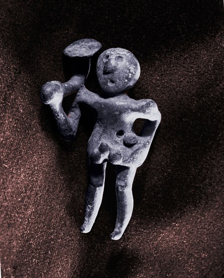Figurine carrying possibly a trumpet or a carnyx