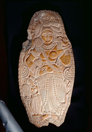Carving of a goddes holding a lotus flower, An attendant at the left