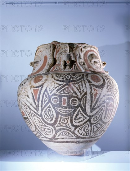 Funerary urn painted with a stylized representation of a crouching female fertility deity