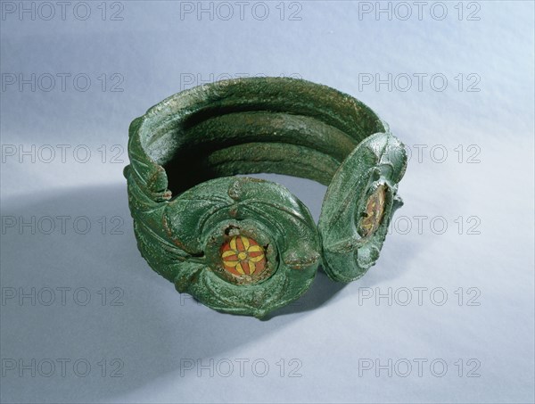 Heavy bronze bracelet decorated with enamelled discs and coloured glass