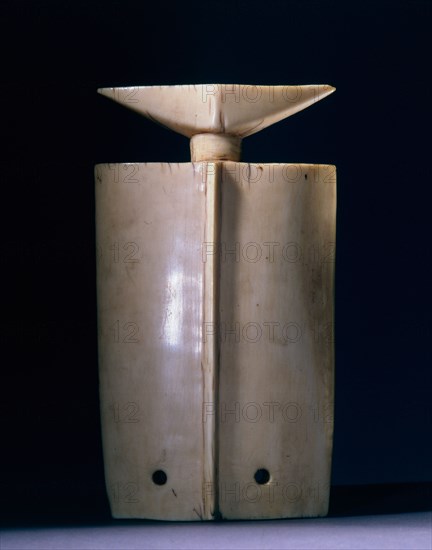 A thungbubiel, an expensive and prestigious ivory ornament, its shape derived from hunters whistles, worn as a pendant by Lobi elders at funerals and festivals