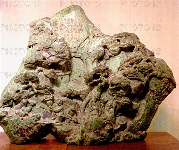 Jade carving depicting a Taoist mythological scene with figures on a mountain path ascending towards pavilions